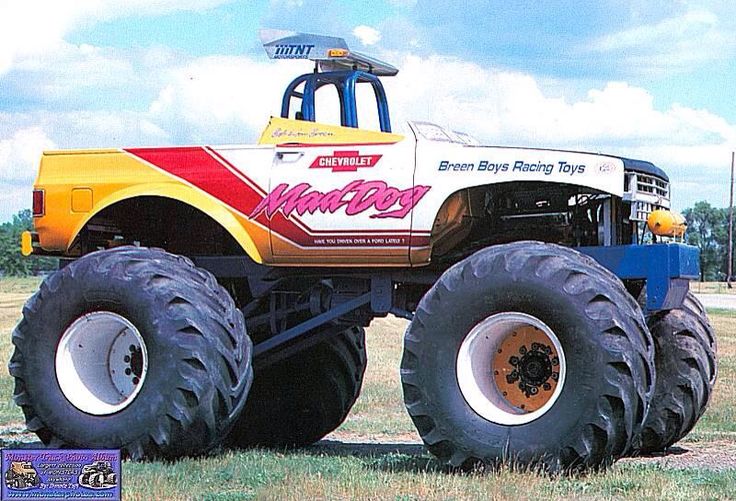 a large monster truck parked on top of a grass covered field