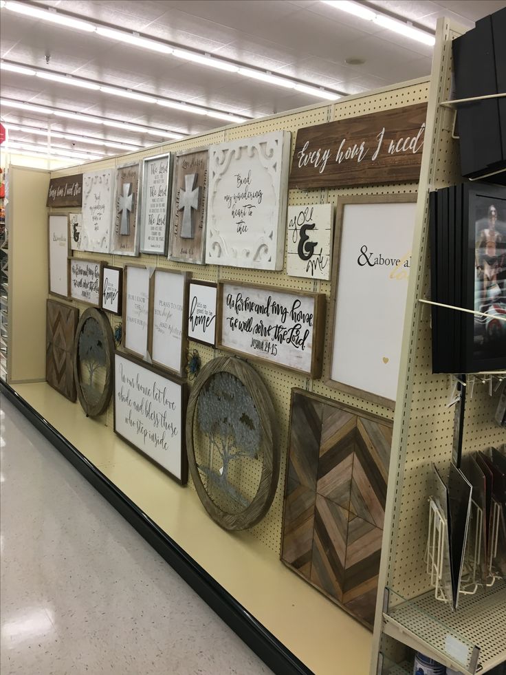 there are many framed pictures on the wall in this store's display area, along with other items for sale