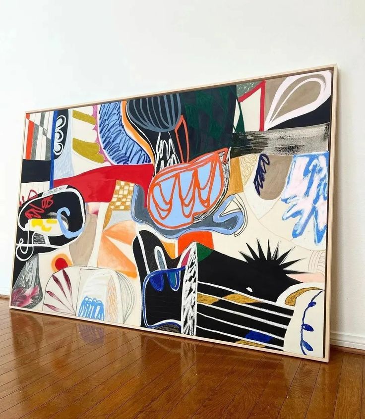 an abstract painting is on display in a room with wood flooring and white walls