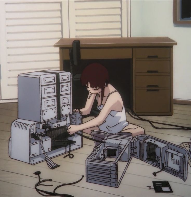 a woman sitting on the floor in front of several computer equipment, with her hands to her face