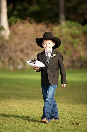 a young boy wearing a cowboy hat and holding a frisbee in his hand