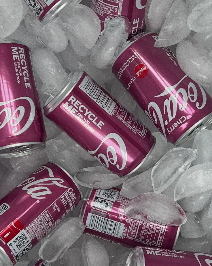 several cans of coca cola sitting on top of ice