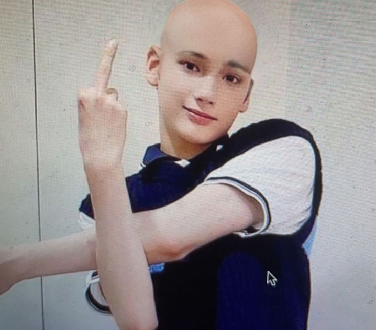 a young man with bald head making the peace sign