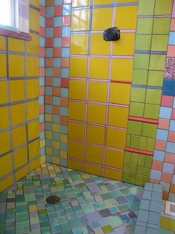 a colorful tiled shower stall in a bathroom