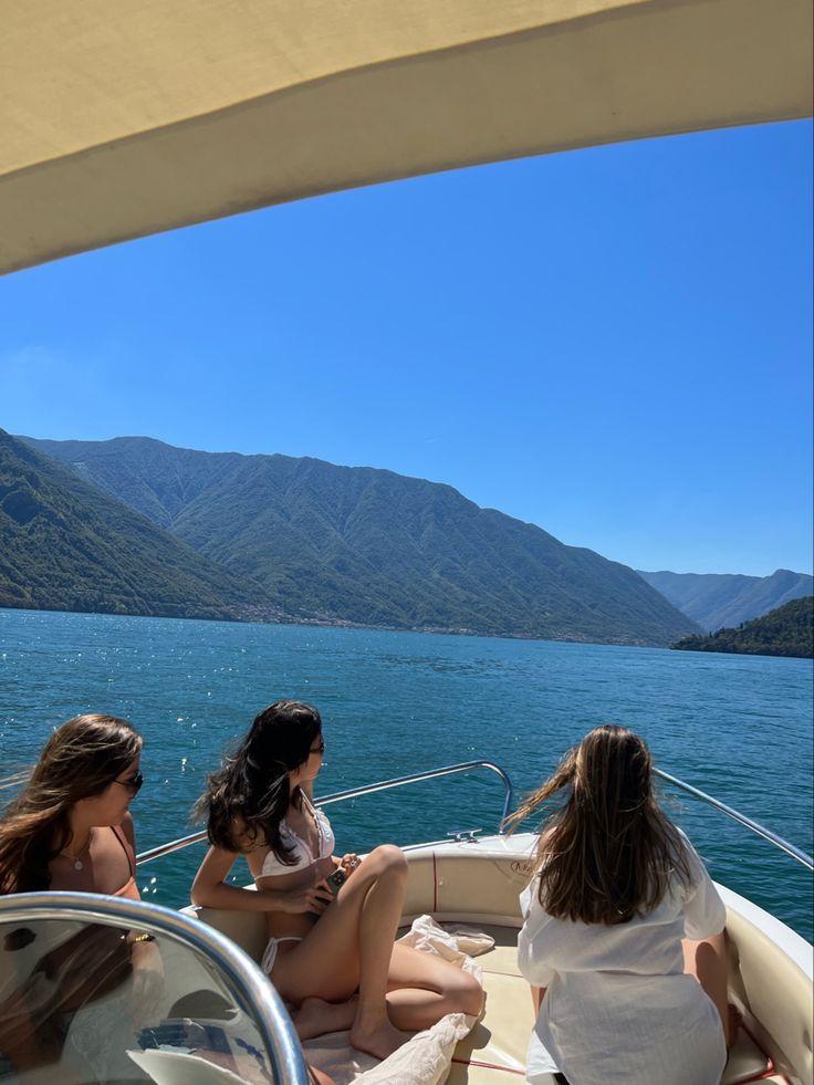 three women sitting on the back of a boat