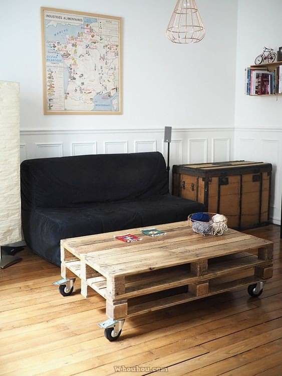 a living room with a couch, coffee table and suitcases on the wooden floor