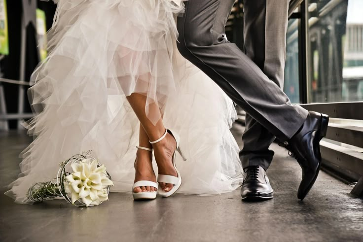 a bride and groom are dancing together on the steps in front of a train station