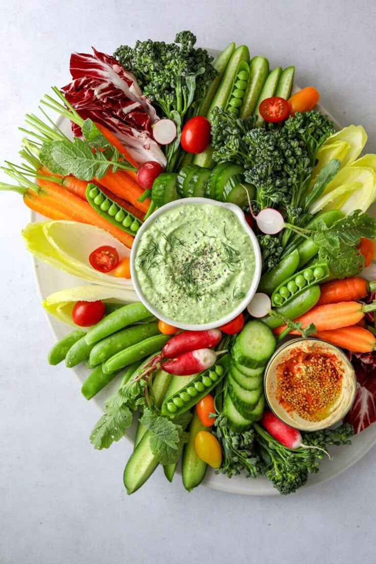 a white plate topped with vegetables and dip