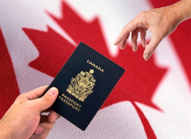 someone holding up a canadian passport in front of the flag