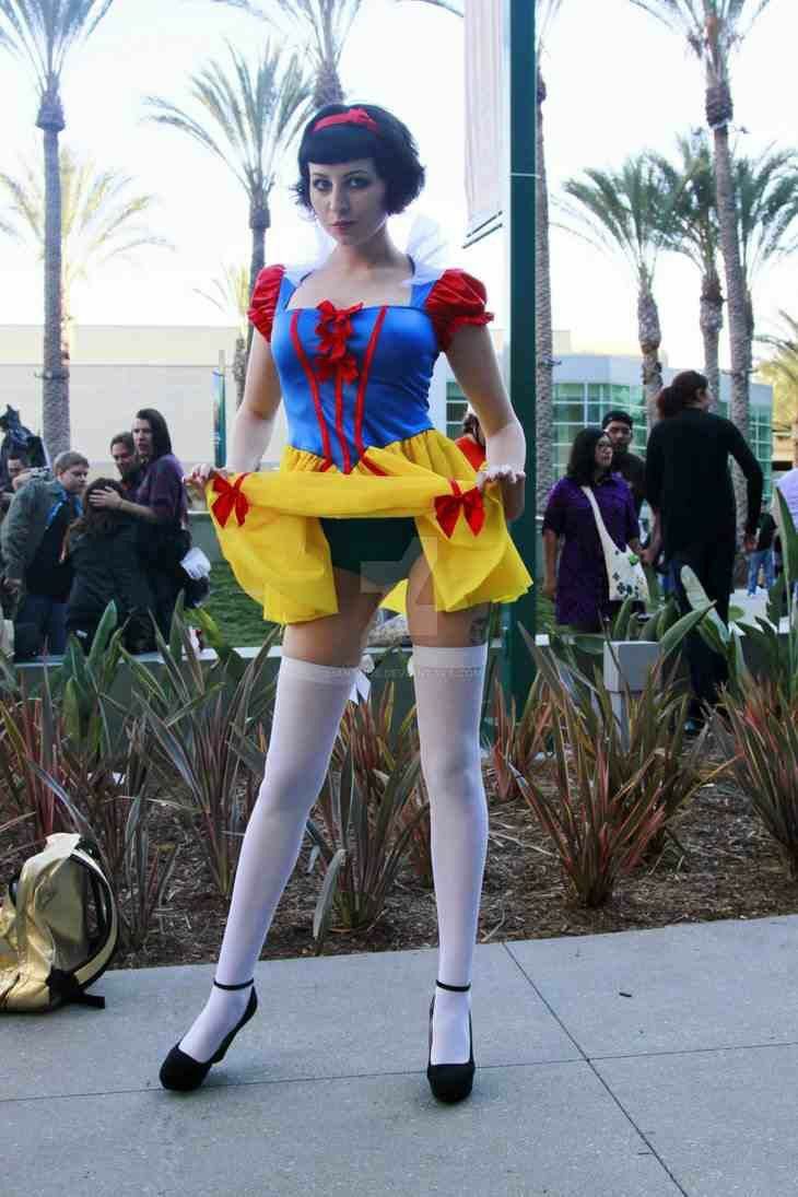 a woman dressed as snow white standing on the sidewalk