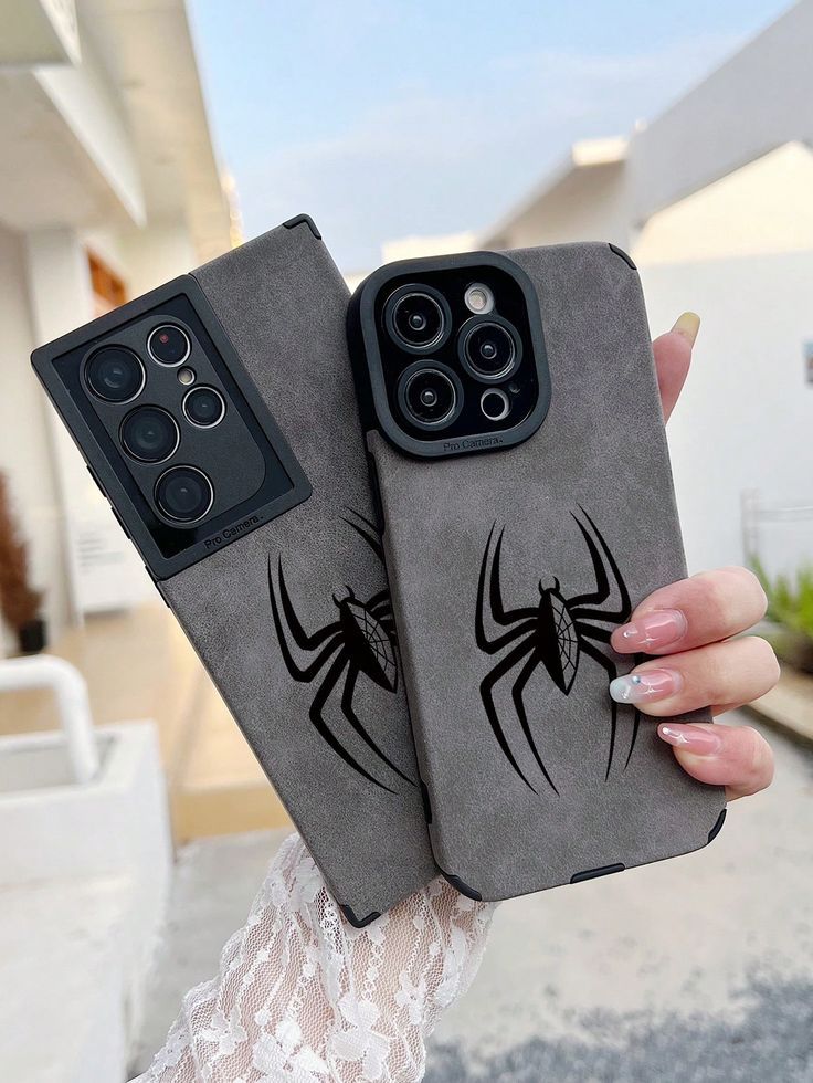 two phone cases with spider - man on them, one is black and the other is gray