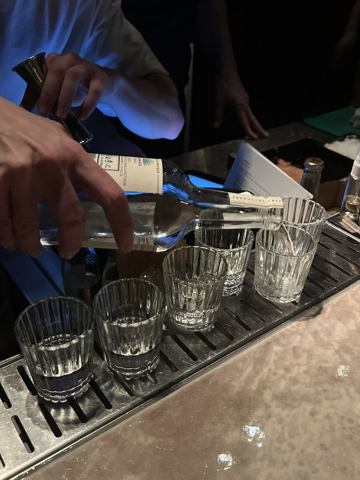 the bartender is making several glasses on the bar