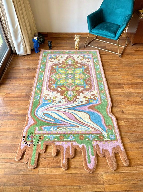 the rug is on the wooden floor in the living room, and it has a blue chair next to it