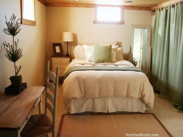 a bed sitting next to a wooden table with a lamp on it's side