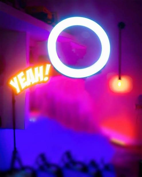 a neon sign that says yeah in front of a room with purple and red lights