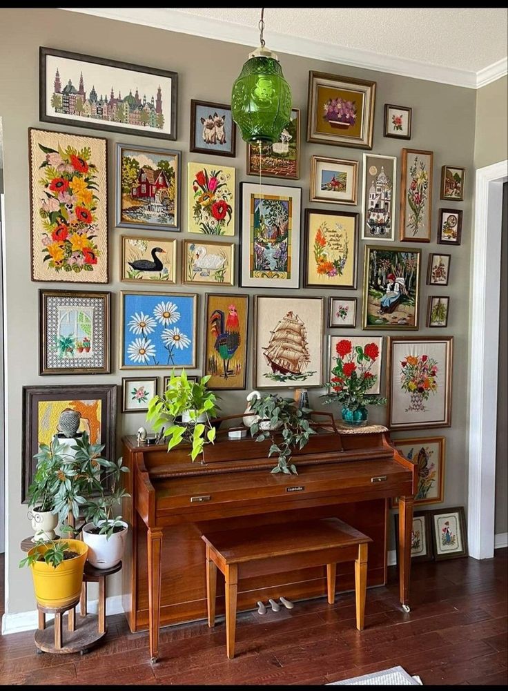 a room with many framed pictures on the wall and a piano in front of it