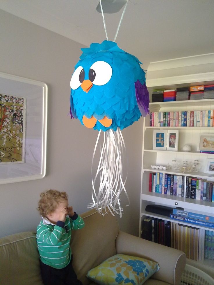 a little boy that is standing in front of a light fixture with a bird on it