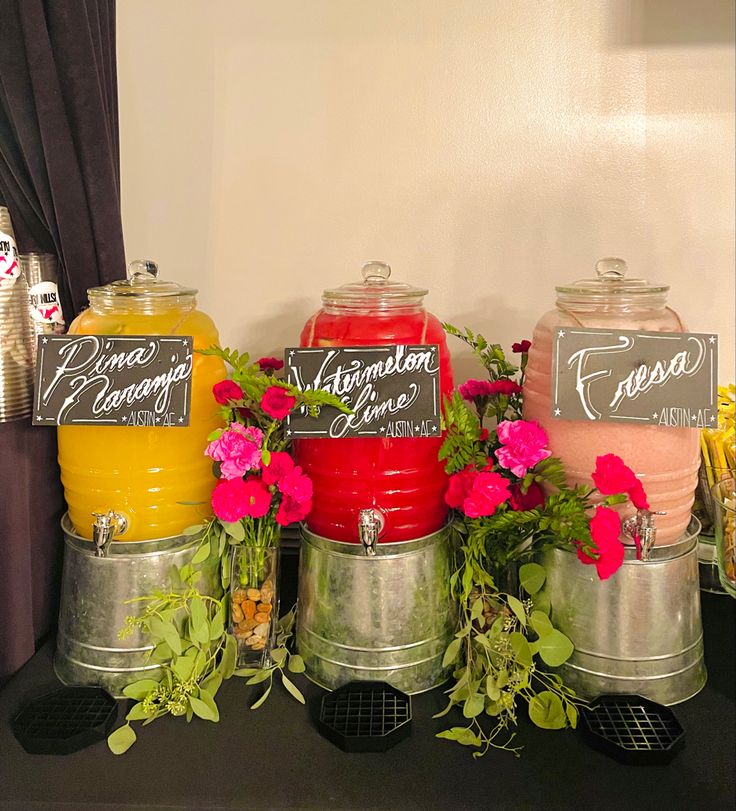 there are many jars with flowers in them on the table and one has a chalkboard sign