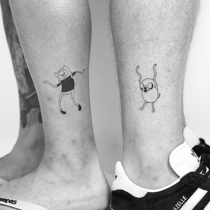 two people with matching tattoos on their legs, one has a cat and the other has a dog