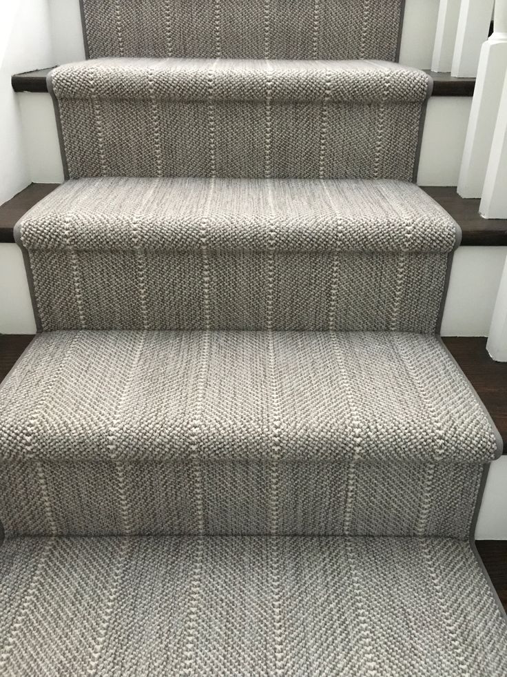 a carpeted stair runner on the bottom of a set of stairs