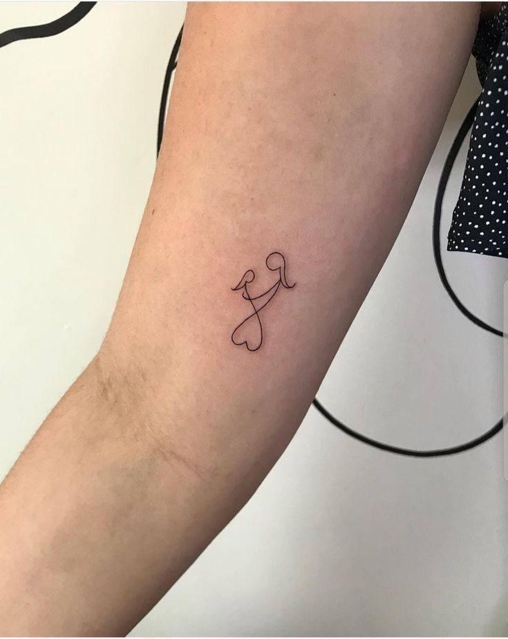 a small tattoo on the arm of a person with a dog bone and crossbone