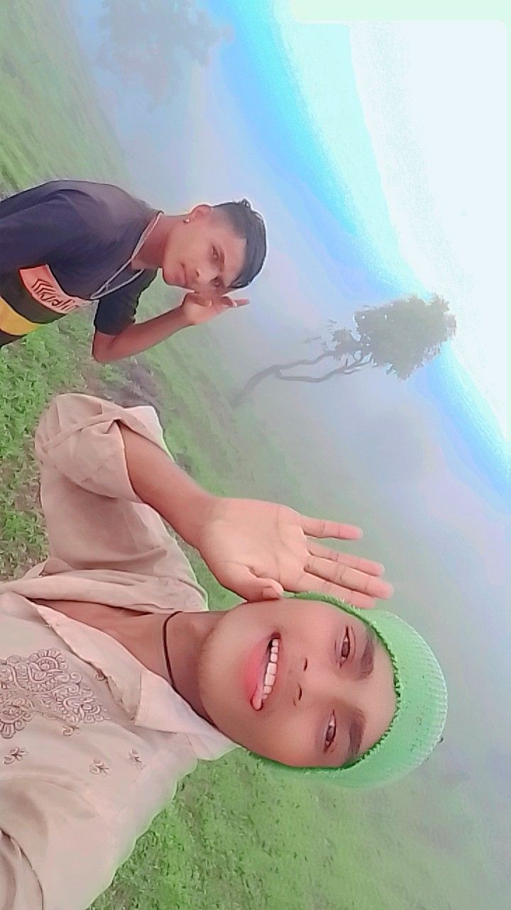 two young boys standing next to each other in the grass