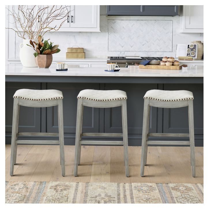 two stools in front of a kitchen island with an area rug on the floor