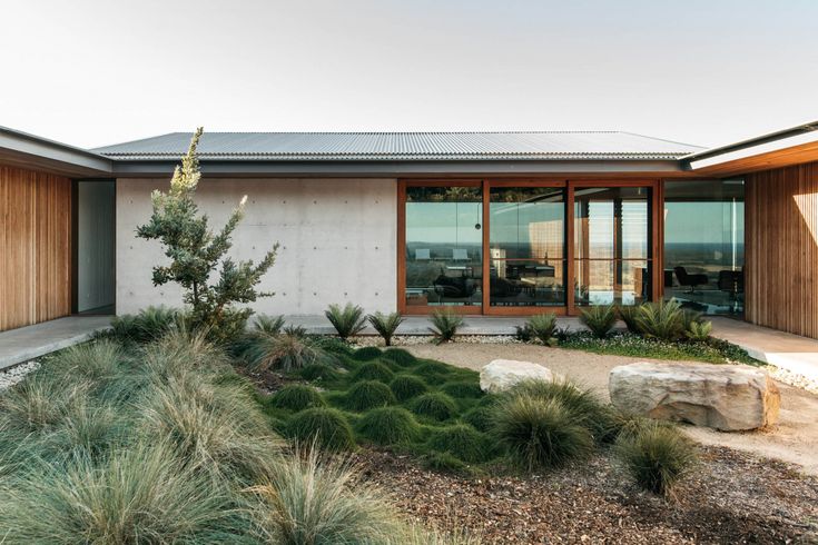 the house is surrounded by grass and rocks