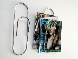 a pair of scissors and magazine clips on a white surface