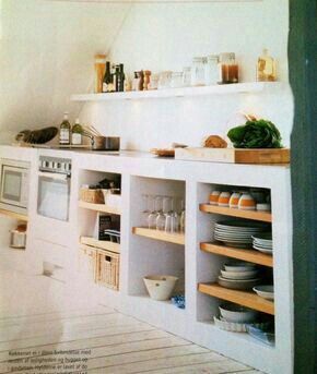 a kitchen with white walls and shelves filled with dishes