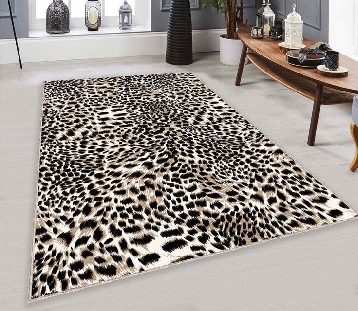 an animal print rug in a living room next to a couch and table with vases on it