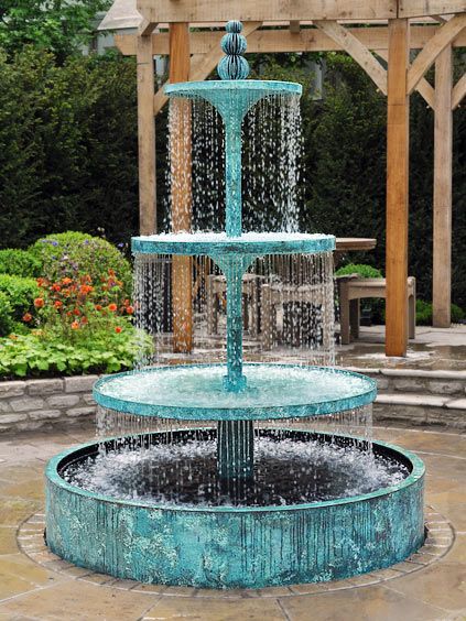 a water fountain in the middle of a garden