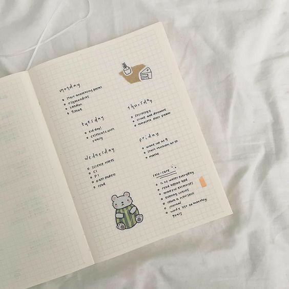 an open notebook with stickers on it sitting on top of a white bed sheet