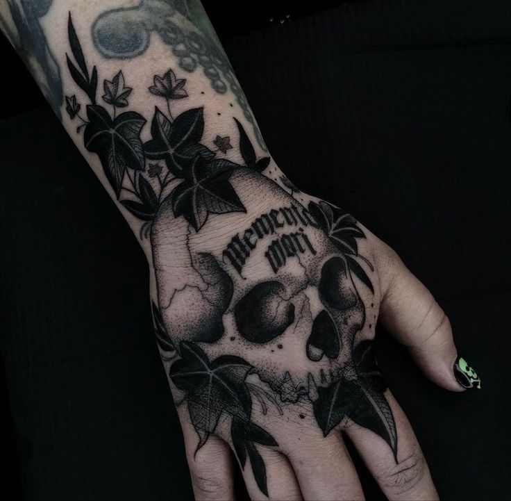 a hand with a skull and flowers on it