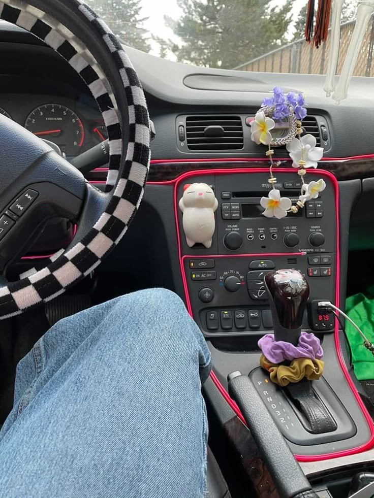 the interior of a car is decorated with flowers and stuffed animals as well as steering wheel controls