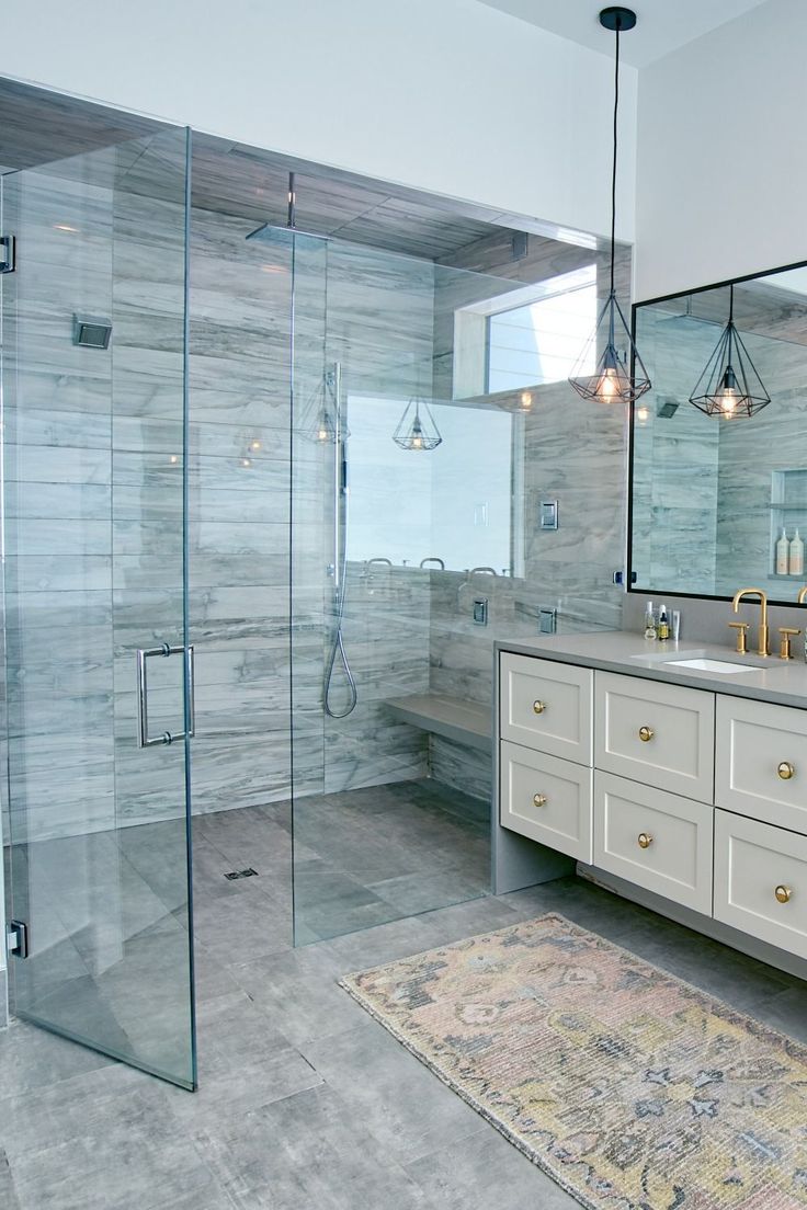 a large bathroom with a walk in shower next to a double sink vanity and mirror