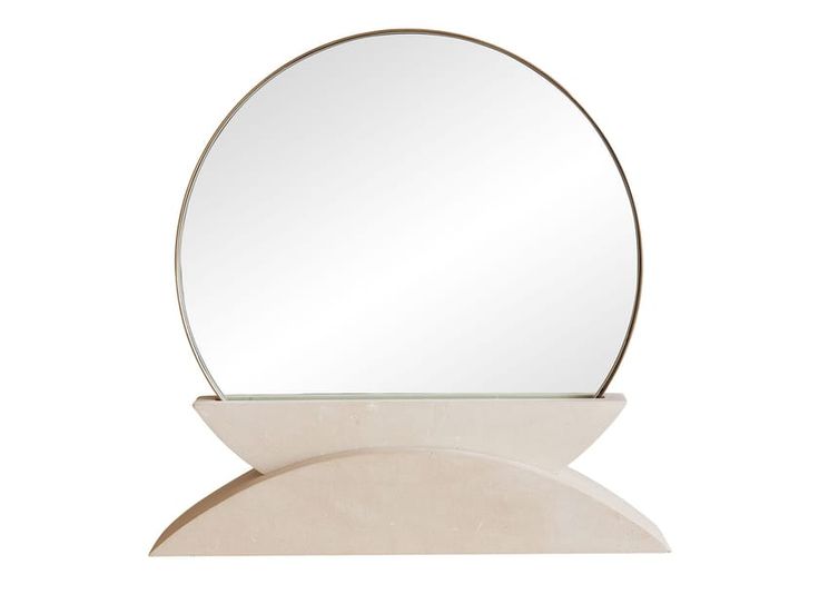 a round mirror sitting on top of a white table