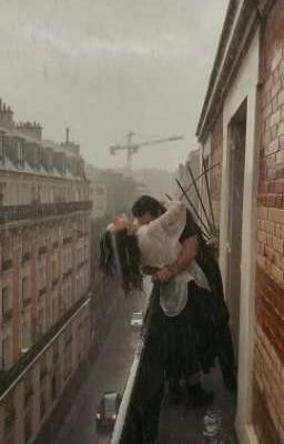 a man and woman kissing on top of a building