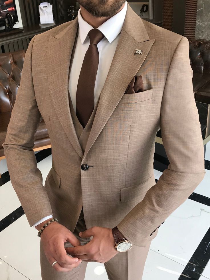 a man wearing a tan suit and tie