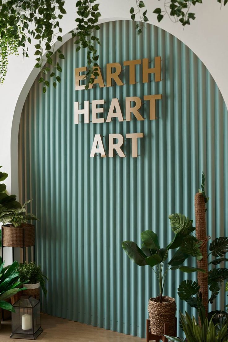 the entrance to earth heart art is surrounded by greenery and potted plants on either side