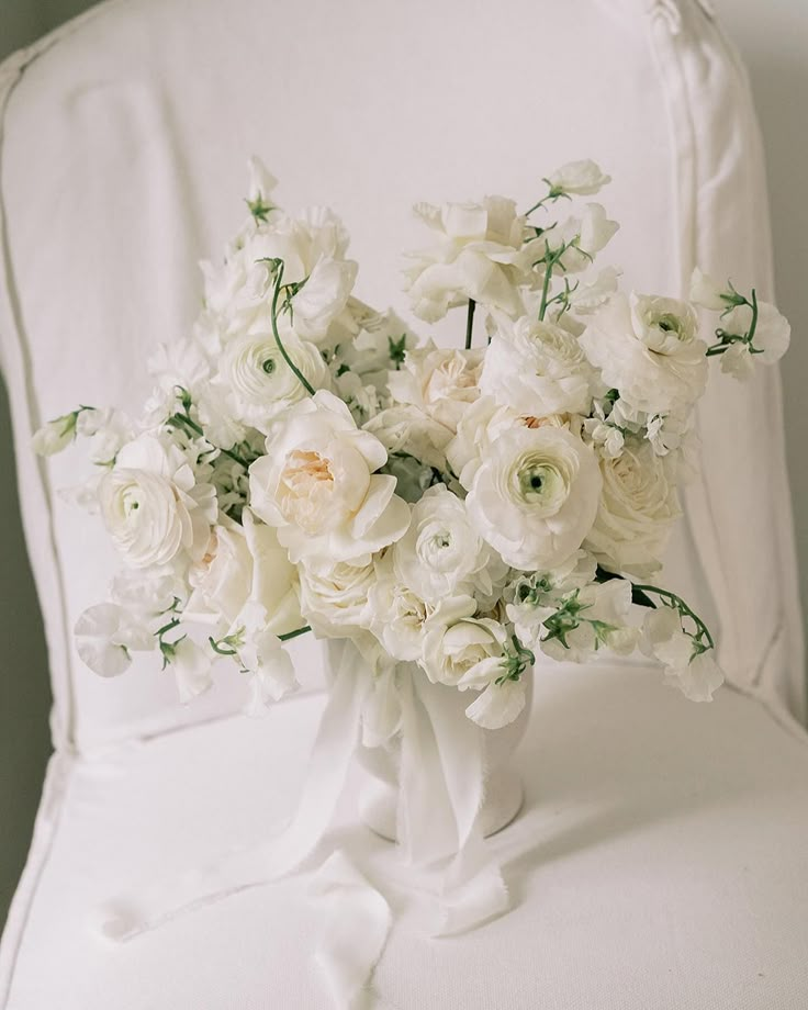 a bouquet of white flowers sitting on top of a chair