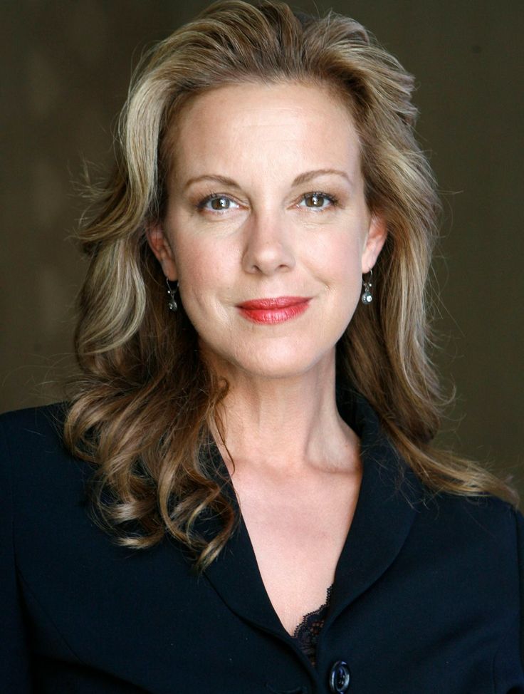 a woman with blonde hair wearing a black shirt and red lipstick is smiling at the camera