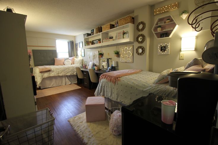 a bedroom with two beds, a desk and shelves on the wall next to each other