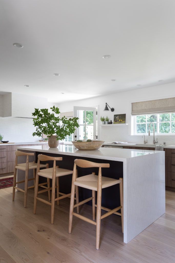 a kitchen with two stools and a center island in the middle of the room