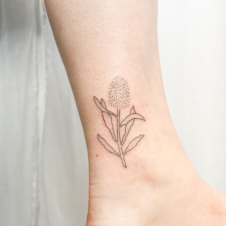 a small tattoo on the ankle of a woman's foot with a flower design