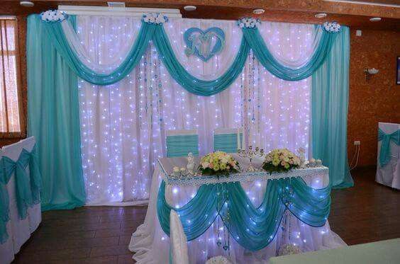 a room decorated in blue and white with lights on the walls, chairs and tables