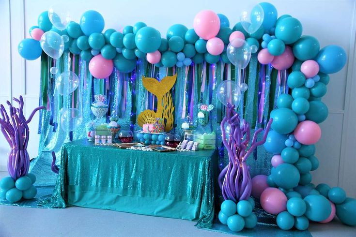 an under the sea themed birthday party with balloons, streamers and mermaid tail decorations