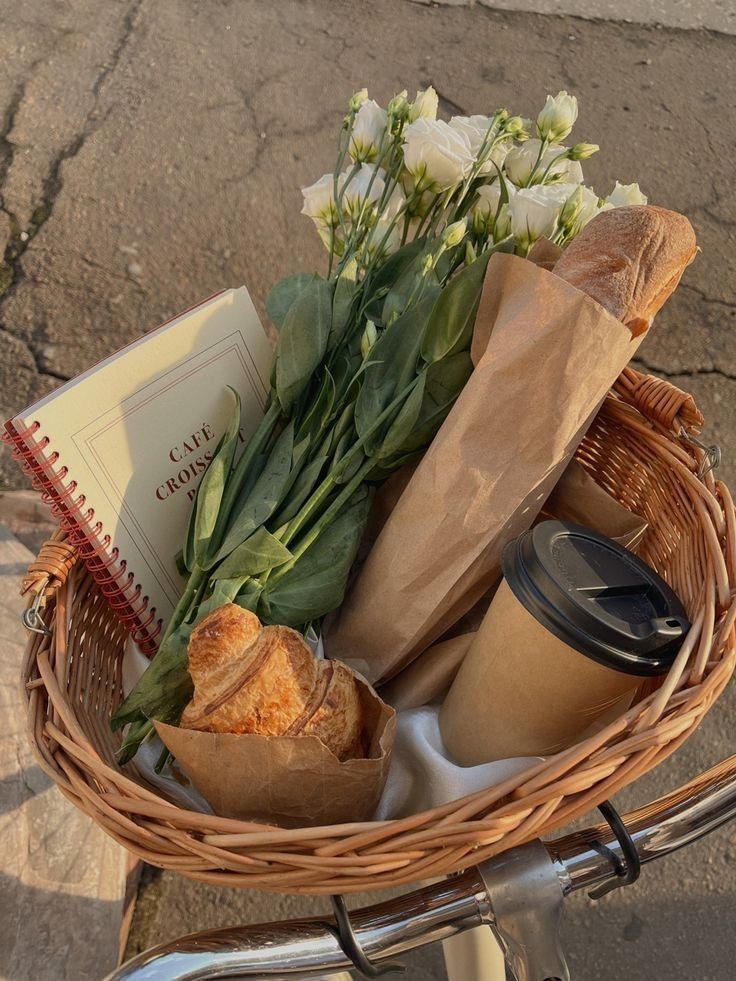 a basket filled with bread and flowers on top of a bike