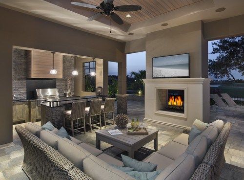 a living room filled with furniture and a fire place in the middle of a kitchen