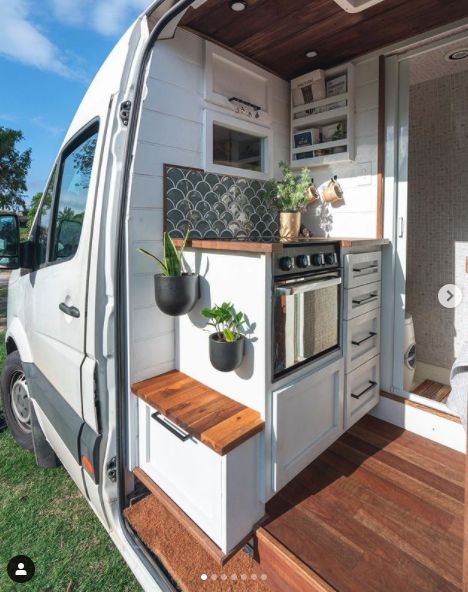 the interior of a tiny home with wood flooring and white walls, including an oven